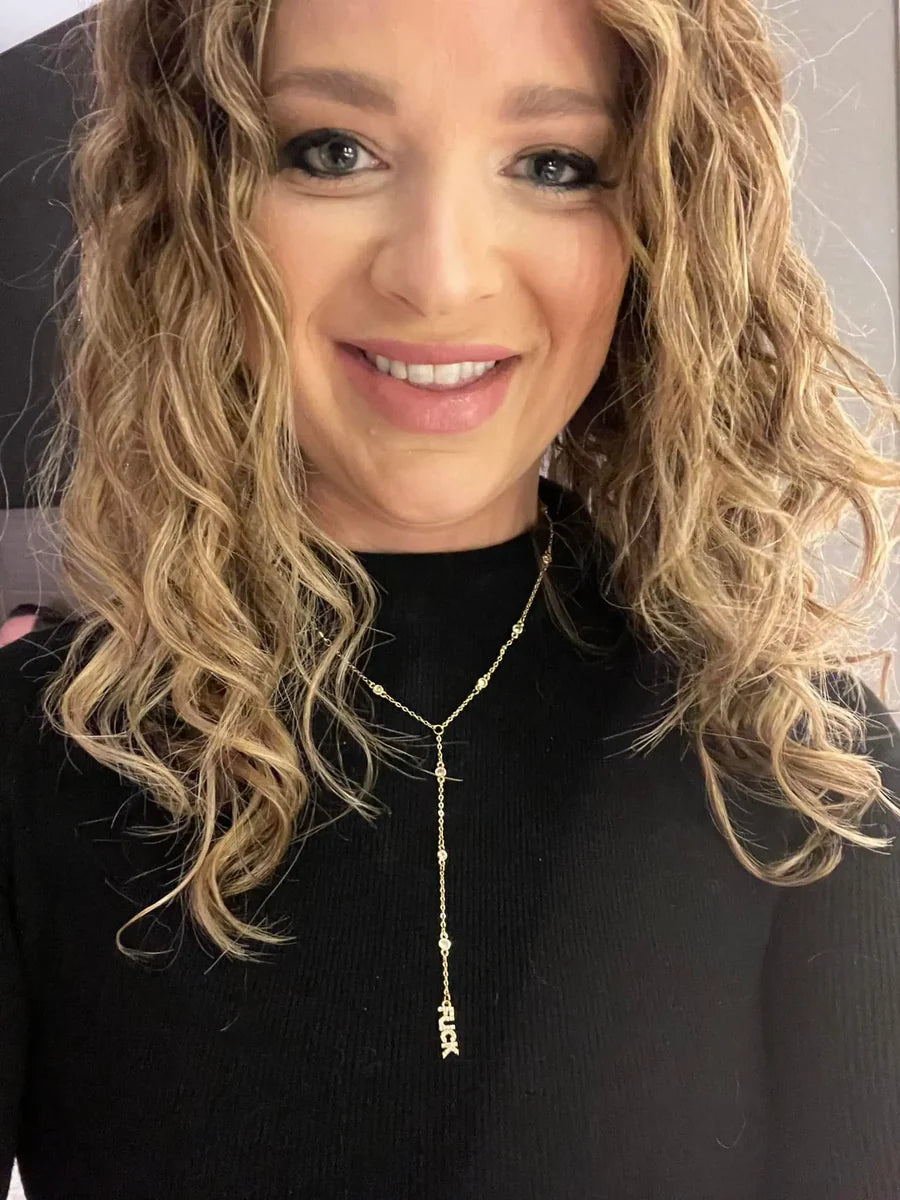 Woman wearing a gold necklace on black sweatshirt